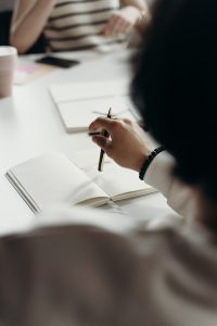 Person in White Long Sleeve Shirt Holding a Pen